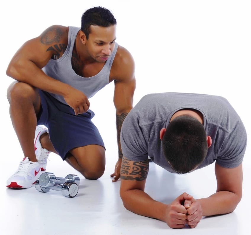 Personal Trainer Helping A Man Do A Plank